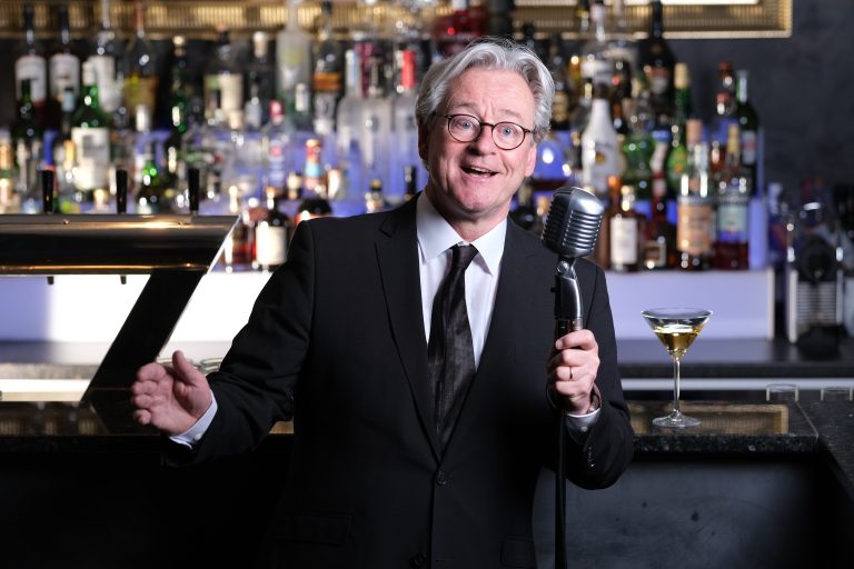 Der Musiker Jochen Hillesheim singend am Mikrofon in einer Bar.