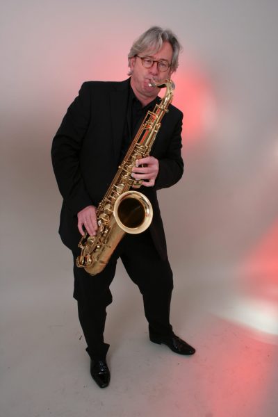 Der Musiker Jochen Hillesheim am Saxophone spielen vor einem weißem Hintergrund.